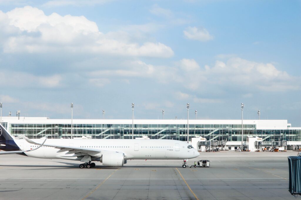 Widebody aircraft parked at an airport gate during clear day with terminal building visible.